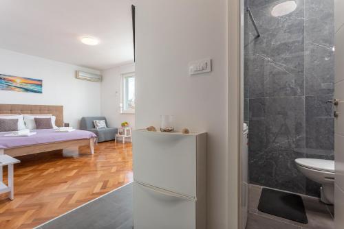 een badkamer met een koelkast en een slaapkamer met een bed bij Botan Apartment in Split