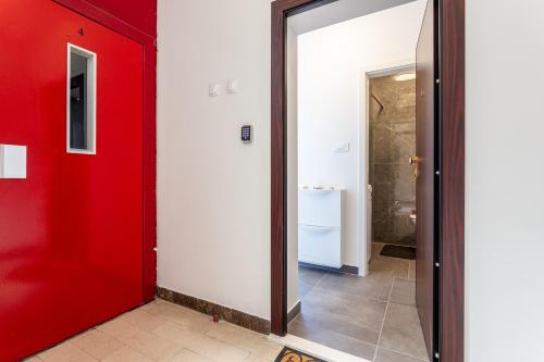 a red door in a hallway with a bathroom at Botan Apartment in Split