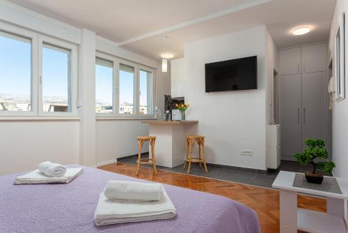 een witte kamer met 2 bedden en een flatscreen-tv bij Botan Apartment in Split