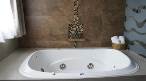 a white bath tub in a bathroom at Hotel Suites Teziutlan in Teziutlán
