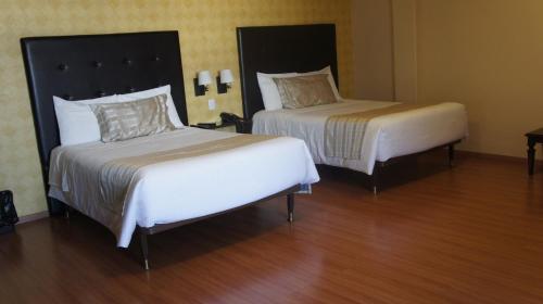 a hotel room with two beds in a room at Hotel Suites Teziutlan in Teziutlán