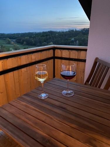 two glasses of wine sitting on a wooden table at Sobe App Moj Hir bed and breakfast in Jastrebarsko