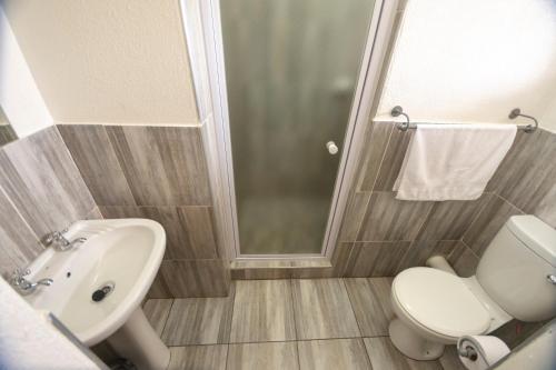 Un baño con inodoro, lavabo y ducha. en Ecomotel Germiston, en Germiston