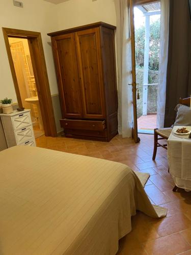 a bedroom with a bed and a cabinet and a door at Valle dei Mulini B&B in Marciana