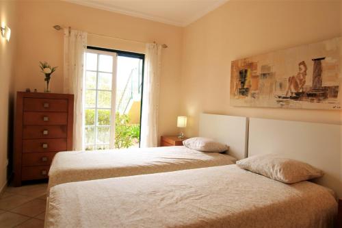 2 Betten in einem Schlafzimmer mit Fenster in der Unterkunft Vilamoura MiraGolf With Pool by Homing in Vilamoura