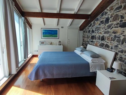 a bedroom with a bed and a stone wall at La Pietra del Golfo in La Spezia