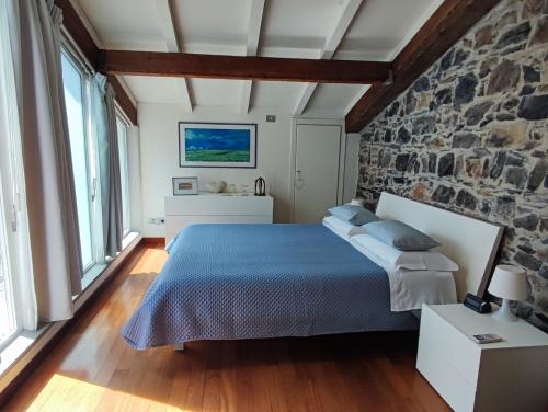 una camera con letto e parete in pietra di La Pietra del Golfo a La Spezia