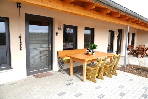 a wooden table and chairs on a patio at Weinbergshof Rickel in Kitzingen