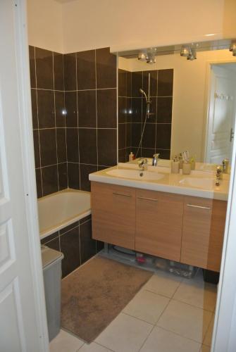 een badkamer met een wastafel, een bad en een spiegel bij Appartement T3 - résidence de standing vue vignes in La Croix-Valmer