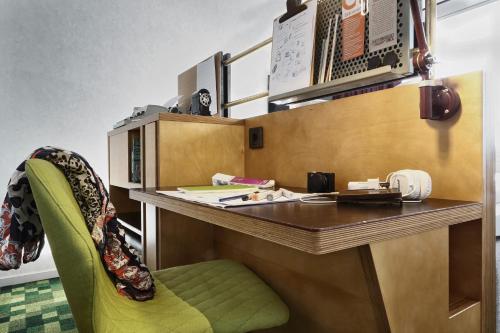 a desk with a green chair in a room at U&Me; BW Signature Collection in Umeå