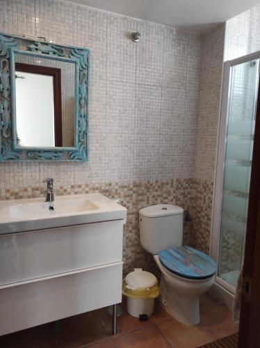 a bathroom with a toilet and a sink and a mirror at Laylas Beach Art House in El Cotillo