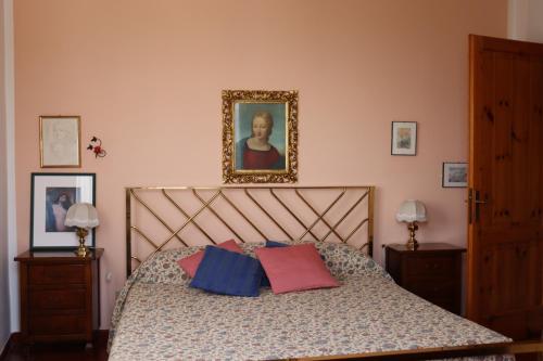 łóżko z dwoma poduszkami i zdjęciem na ścianie w obiekcie Monika Holiday 88 Astro sul Garda w mieście Costermano