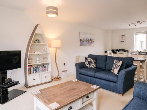 a living room with a blue couch and a table at Stone's Throw in Charlestown