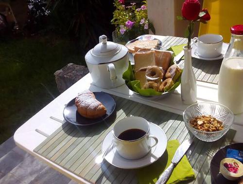 a table with a tea pot and coffee and pastries at Il Pittore di Stelle B&B in Boissano