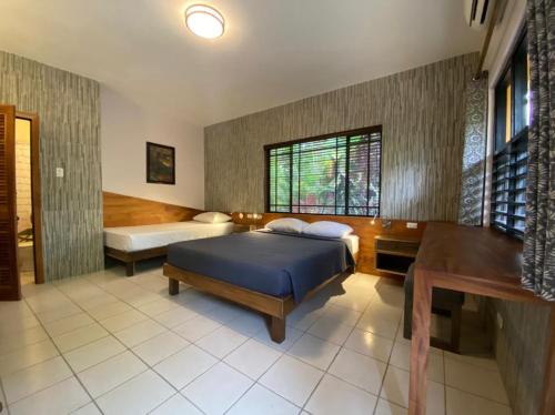 a bedroom with a bed and a desk and a window at Sunrise Club Hotel in Negril