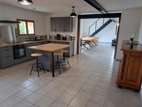 a kitchen with a table and some stools in it at Charmante maison a la ferme in Bonnes