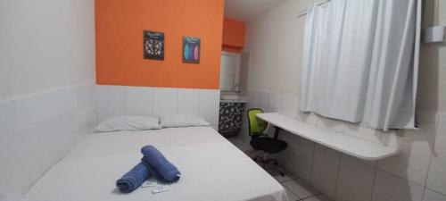 a small room with a bed with a blue item on it at Casa Recife Pousada in Recife
