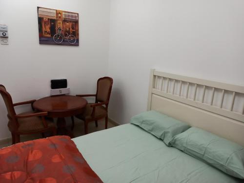 Furnished Apartment في الشارقة: غرفة نوم بسرير وطاولة وكراسي