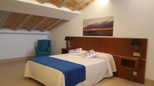 a bedroom with a bed and a blue chair at HOTEL ISLA PLANA in Tabarca