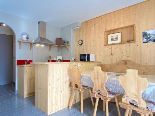 - une cuisine avec des murs en bois, une table et des chaises dans l'établissement Joli chalet 60m2 proche du centre. parking. balcon, à Cauterets