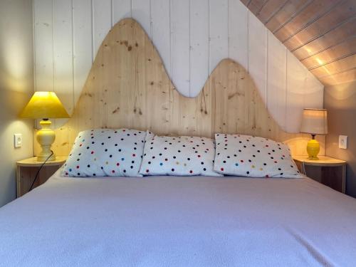 a bedroom with a large white bed with two lamps at Joli chalet 60m2 proche du centre. parking. balcon in Cauterets
