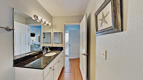 a bathroom with a sink and a mirror at Madeira Bay Resort II by Travel Resort Services in St Pete Beach