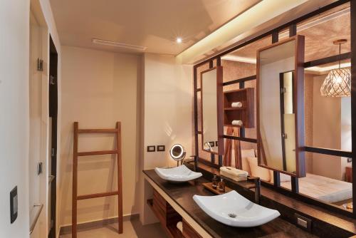 
a bathroom with two sinks and a large mirror at Mvngata Boutique Hotel in Playa del Carmen
