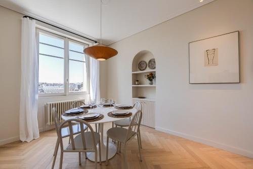a white dining room with a table and chairs at Le Haras 3 bedroom apartment in the heart of Annecy in Annecy