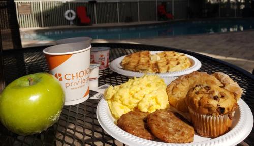 a table with three plates of food and an apple at Comfort Inn & Suites Orlando North in Sanford