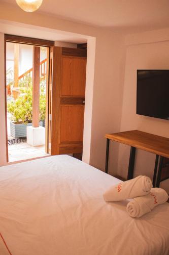 a bedroom with a bed with a flat screen tv at Masaya Bogotá in Bogotá