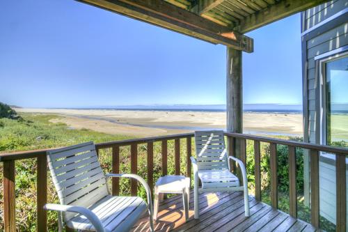 two chairs on a porch with a view of the beach at Little Creek Cove Beach Resort in Newport
