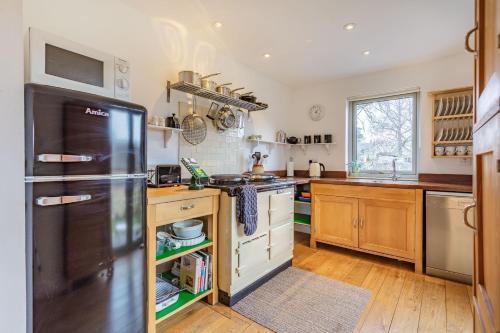 a kitchen with a stainless steel refrigerator and wooden cabinets at Inshcraig in Kincraig