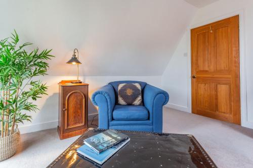 a living room with a blue chair and a table at Inshcraig in Kincraig