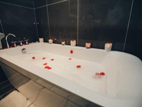 a bath tub with candles and red hearts on it at Hotel Romeo in Korçë