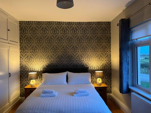 a bedroom with a bed with two towels on it at Pat's Cottage in Kinawley