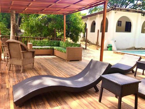 a wooden deck with chairs and tables and an umbrella at Hotel Minca - La Casona in Minca