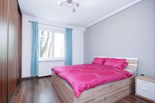 sypialnia z różowym łóżkiem i oknem w obiekcie Trenčianska Apartment w mieście Trnávka