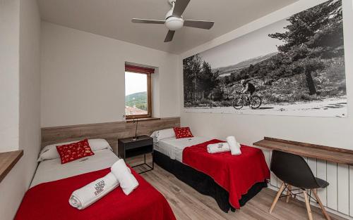 Un dormitorio con dos camas y un ventilador de techo. en CicloLodge, en Lozoya
