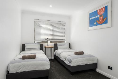 Giường trong phòng chung tại 24 Hibiscus Crescent Port Macquarie