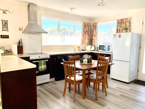 a kitchen with a table and chairs and a refrigerator at Rotorua City Center Holiday House in Rotorua