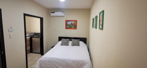 - une chambre avec un lit doté de draps et d'oreillers blancs dans l'établissement Habitación B independiente para parejas o ejecutivos, à Manta