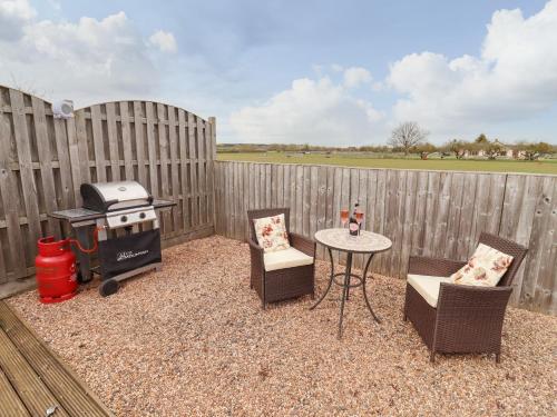a backyard with a grill and chairs and a table at Parlour Barn in Charlton