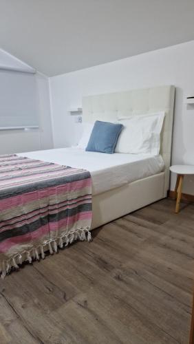 a bedroom with a large bed with a blue pillow at A.l. KATEKERO in Costa Nova