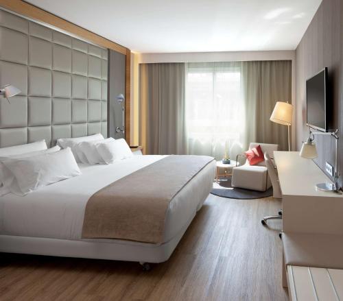 a hotel room with a large bed and a television at NH Collection San Sebastián Aranzazu in San Sebastián