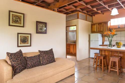 ein Wohnzimmer mit einem Sofa und einer Küche in der Unterkunft Coffee Garden Ranch Costa Rica in Concepción