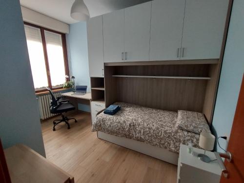 1 dormitorio con 1 cama y escritorio con ordenador portátil en La Casa del Birraio, en Sondrio