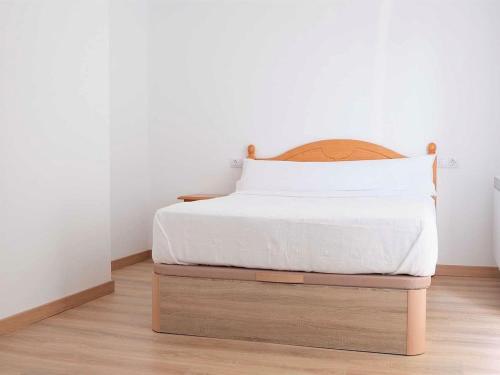 een bed met een houten hoofdeinde in een kamer bij Elegant Apartment in Ourense with Private Terrace in Ourense