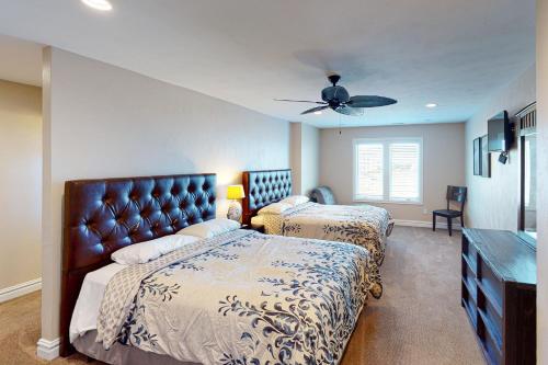 a bedroom with two beds and a ceiling fan at Aria in Virginia Beach