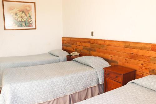 a room with three beds and a picture on the wall at Hotel Terramar in Talcahuano