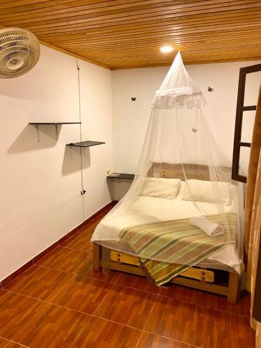 a bedroom with a bed with a net on it at Hotel Minca - La Casona in Minca